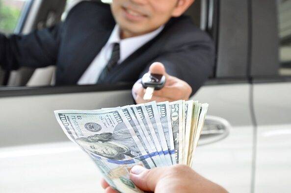 Persona entregando dinero por la venta de un auto